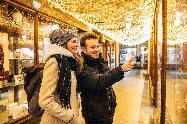 Ein Pärchen schaut sich in einem Schaufenster von den Arkaden Leipzig die ausgestellten Waren an.