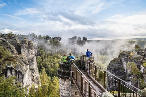 Aussichtsplattform in der Sächischen Schweiz bei der Bastei. Im Hintergrund Felsen und Wolken.